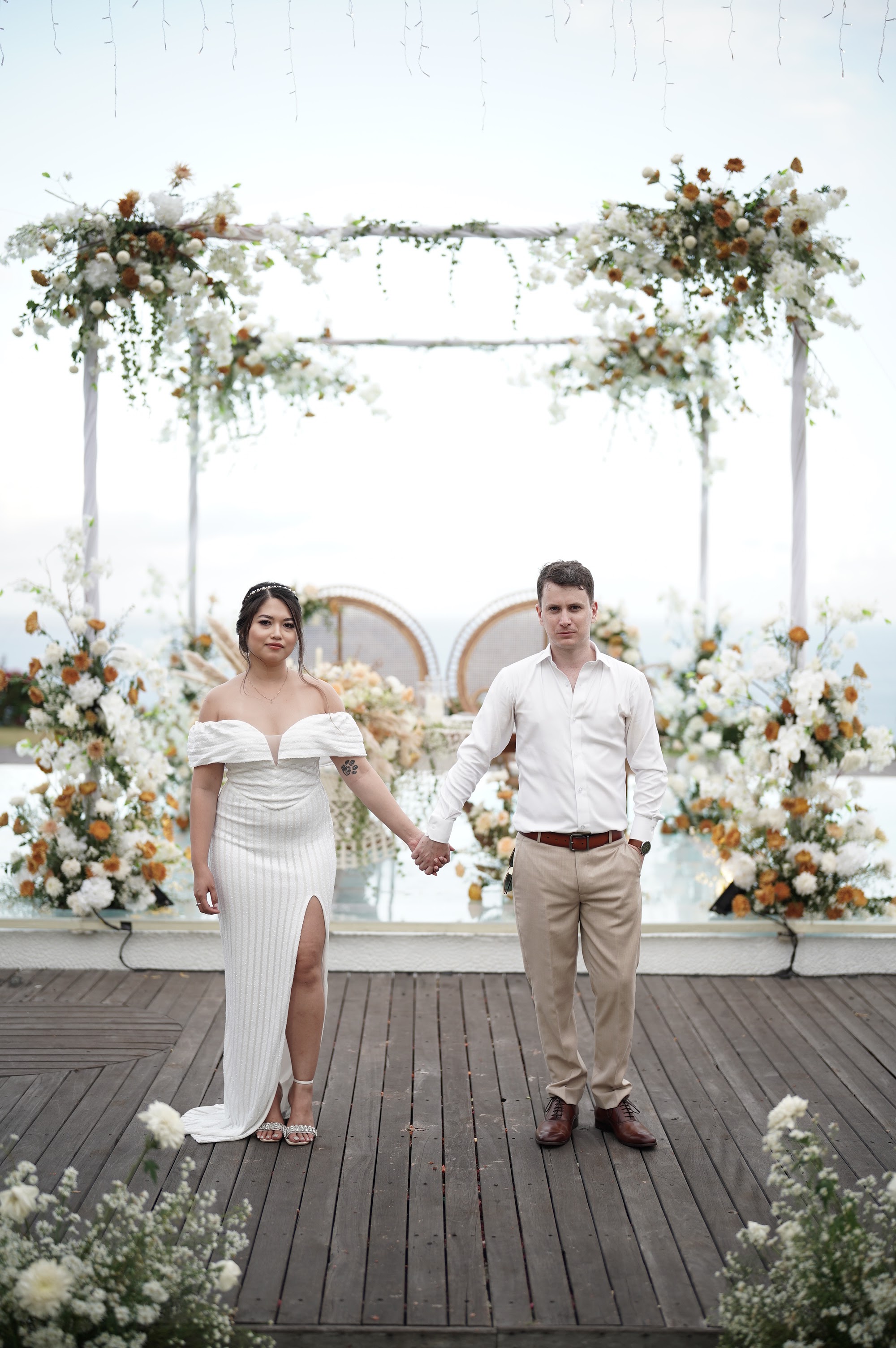 Martin and Camille beneath their ceremony florals