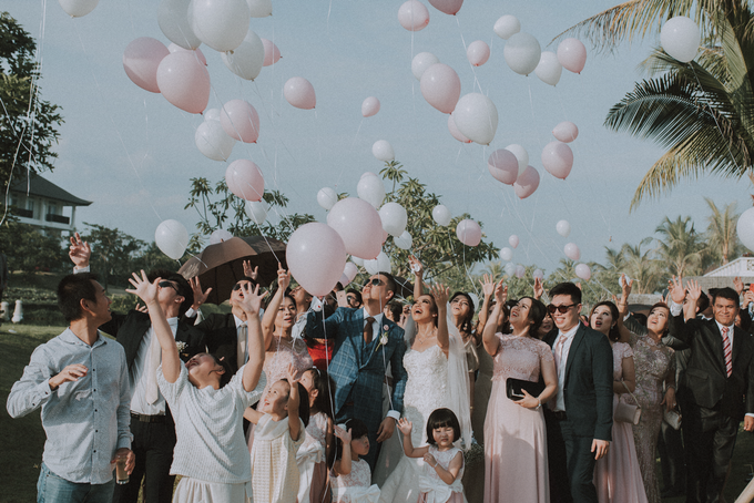 Tony and Melani celebrating with guests and blush balloons